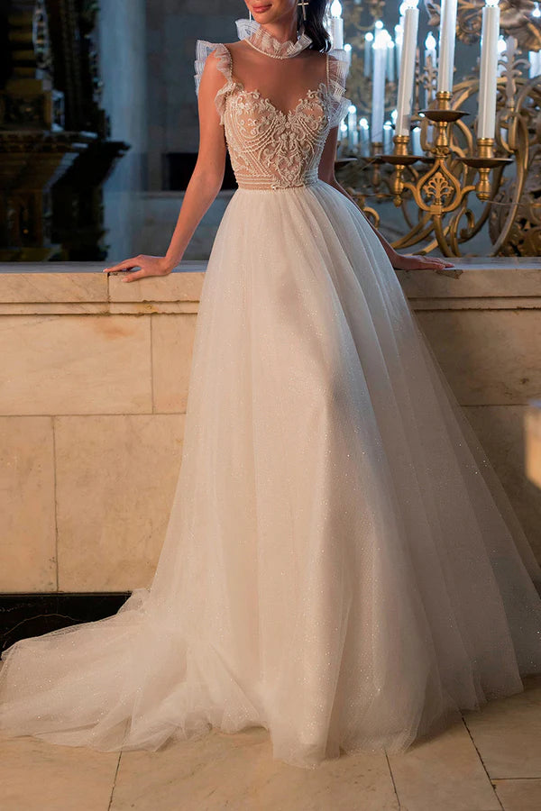 Un abito da sposa bohémien con illusione di filo e perline scintillanti sulla scollatura